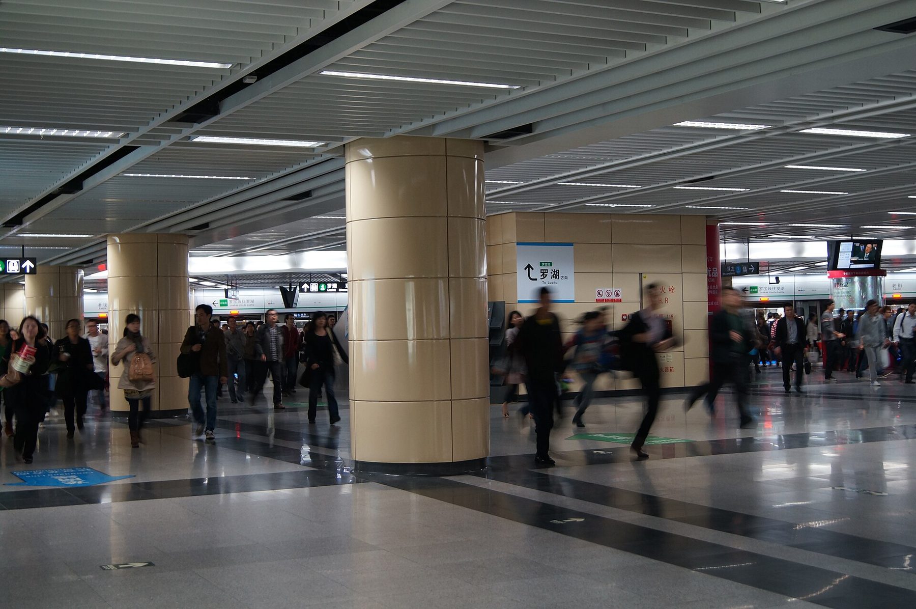 A blurred crowd of commuters rushing through a train station