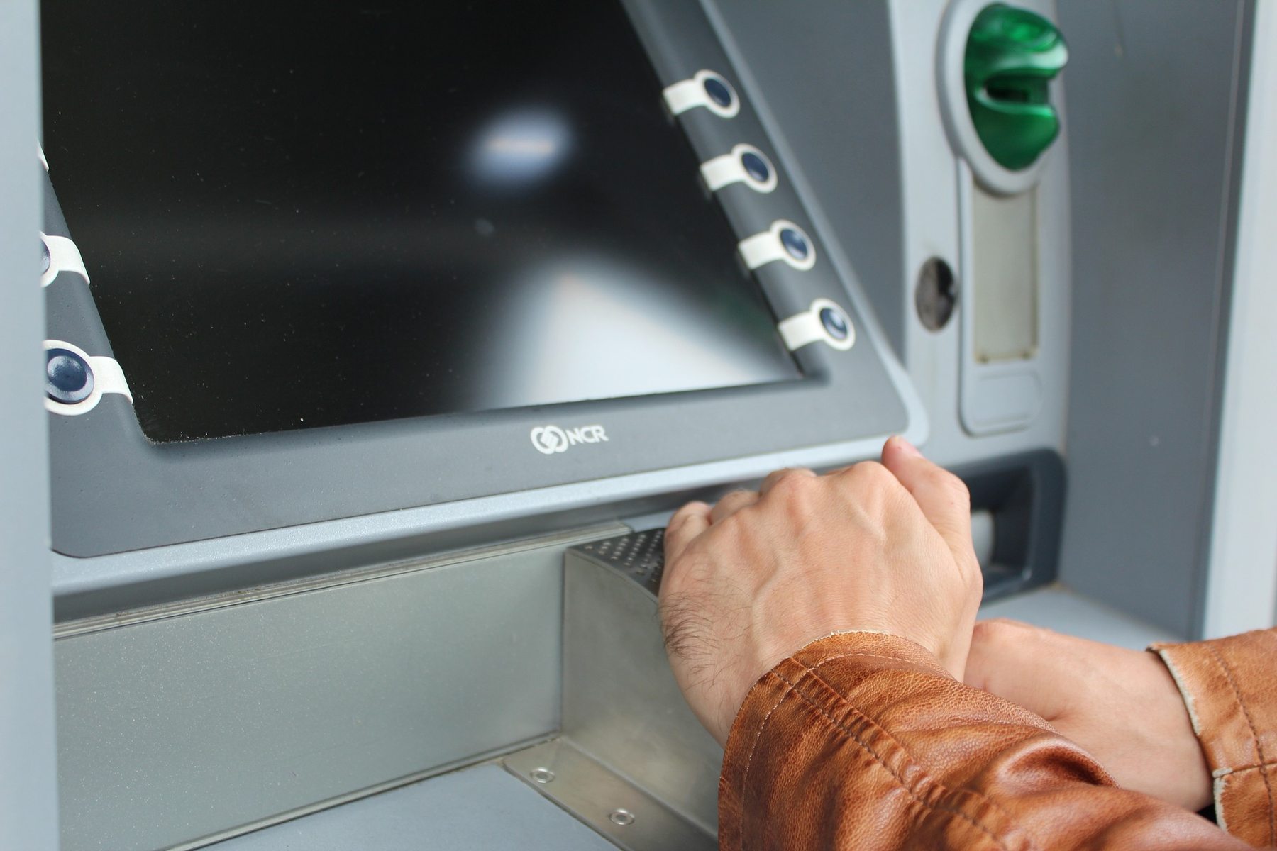 A person's hands at an ATM machine
