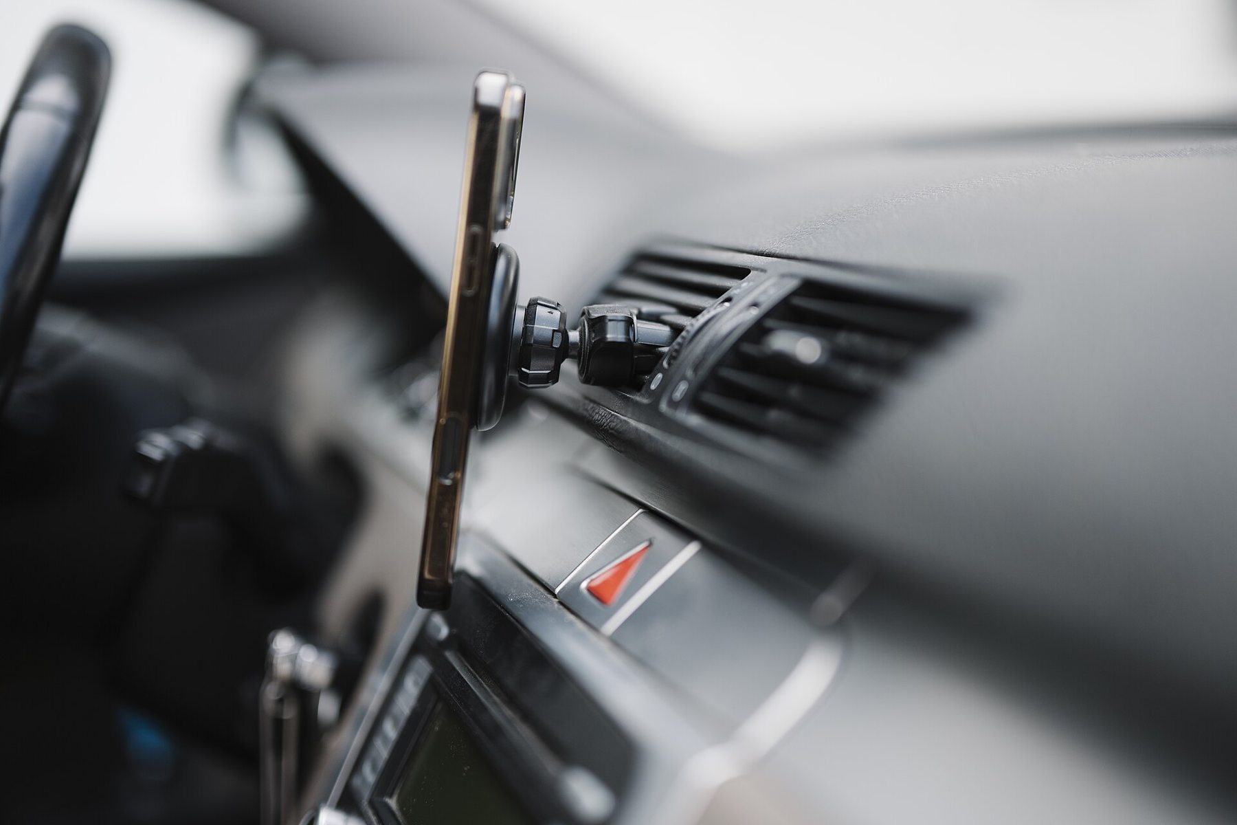 A smartphone mounted on a car dashboard, showing a navigation app