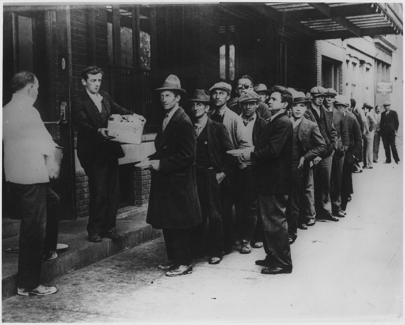 A long breadline of unemployed men waiting for food during the Great Depression